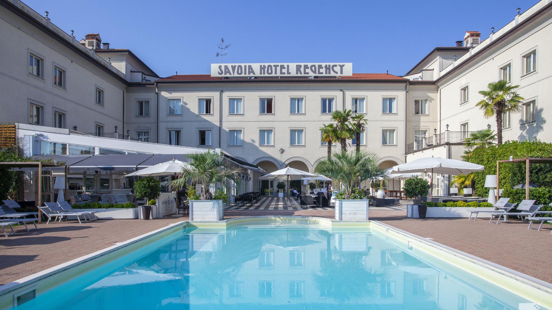 Het buitenzwembad met ligbedden bij Savoia Hotel Regency